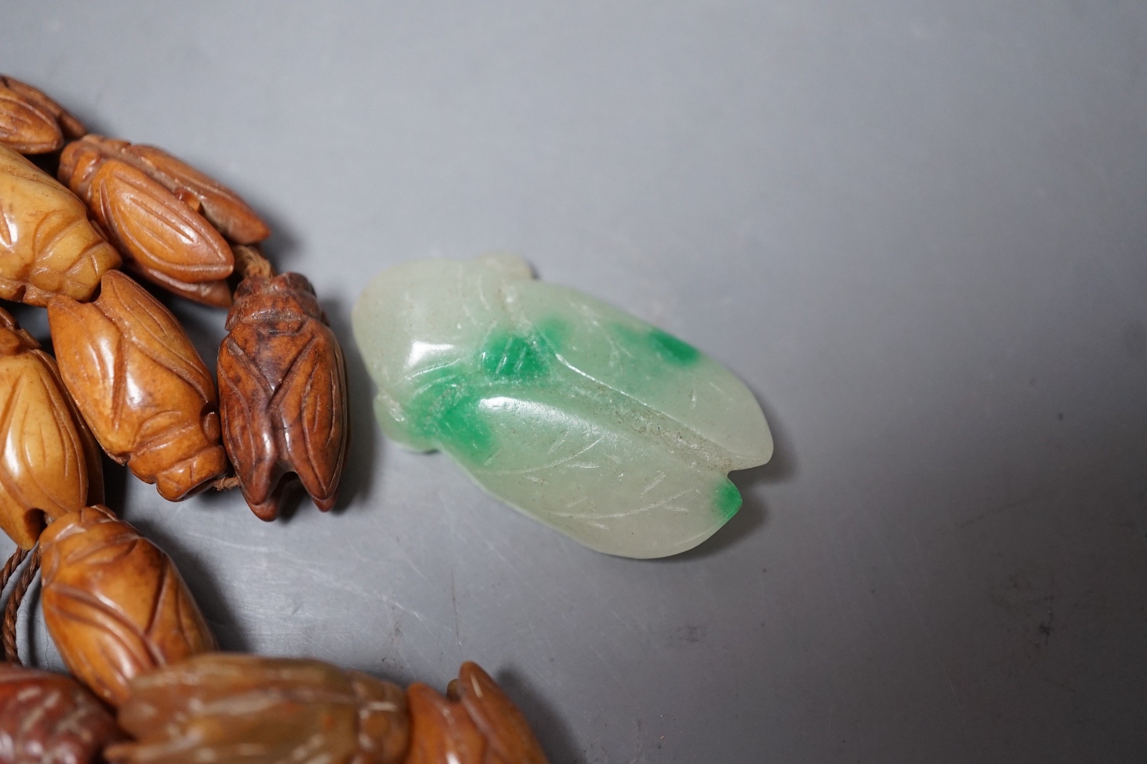 Chinese carved Hardstone ‘cicada’ bead necklace, a carved hardstone plaque a jadeite pipe mouthpiece and similar cicada